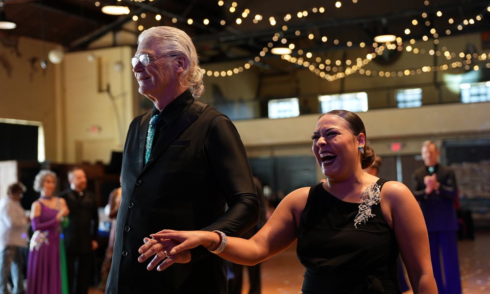 A competitor overcome after her heat at OK Dancesport, her partner steady beside her